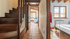 A staircase leading to a bedroom with a bed, a window, and a radiator. - Il GECO Holiday Home (Tortoli')