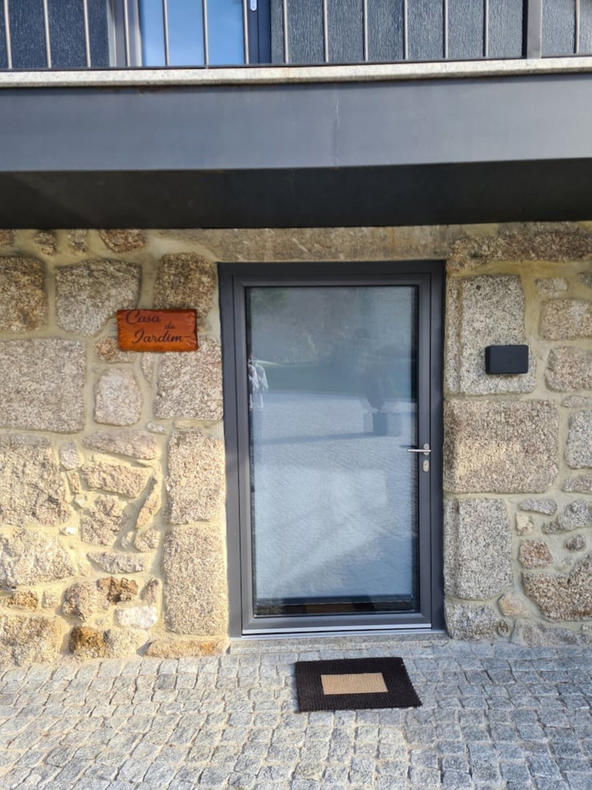 Un edificio de piedra con una puerta oscura y un letrero que dice "Casa da Jardim".