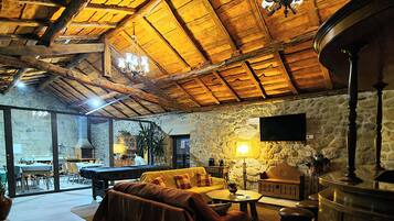 Un interior acogedor con techo de madera, un sofá, una mesa y una zona de bar.