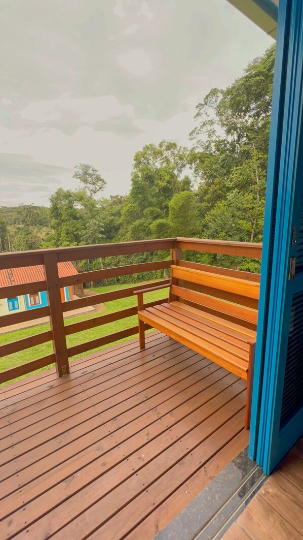 Une terrasse en bois avec un banc et une porte bleue.