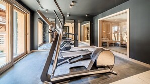Une salle de sport moderne équipée de tapis de course, d’un vélo d’appartement et d’un rameur.