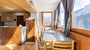 Une cuisine avec des meubles en bois, un plan de travail en granit et une fenêtre avec des rideaux.