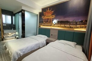 Habitación de hotel con dos camas, una mesita de noche, un espejo y un televisor fijado a la pared.