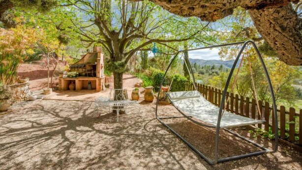 A rustic outdoor seating area with a swing, a wooden structure, and a view of the landscape. - La Renardière by Interhome (Le Tignet)