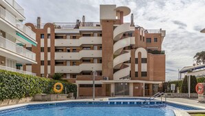 Un edificio moderno de varios pisos con piscina delantera.