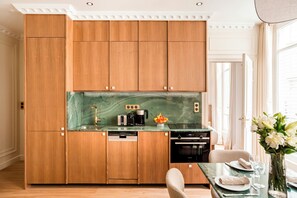 Une cuisine compacte avec des meubles en bois, un plan de travail en marbre et des appareils électroménagers modernes.