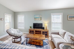 Relax in a cozy seating area with a comfortable chair and sofa, flat-screen TV, and a beautiful painting on the wall.