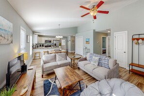 Relax in a spacious living area with a comfortable sofa, flat-screen TV, and dining table.