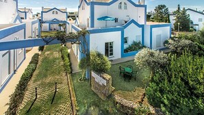 Un quartier résidentiel avec des maisons modernes, une cour verdoyante et un mur en pierre.