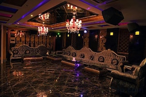 Una habitación lujosa con muebles ornamentados, candelabros y piso pulido.