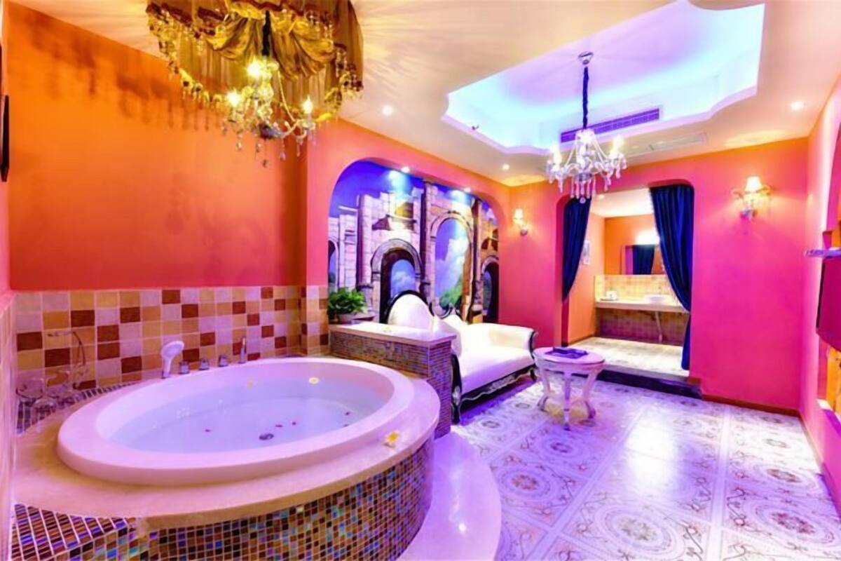 A bathroom with a large bathtub, a shower area, and a vanity with a mirror.