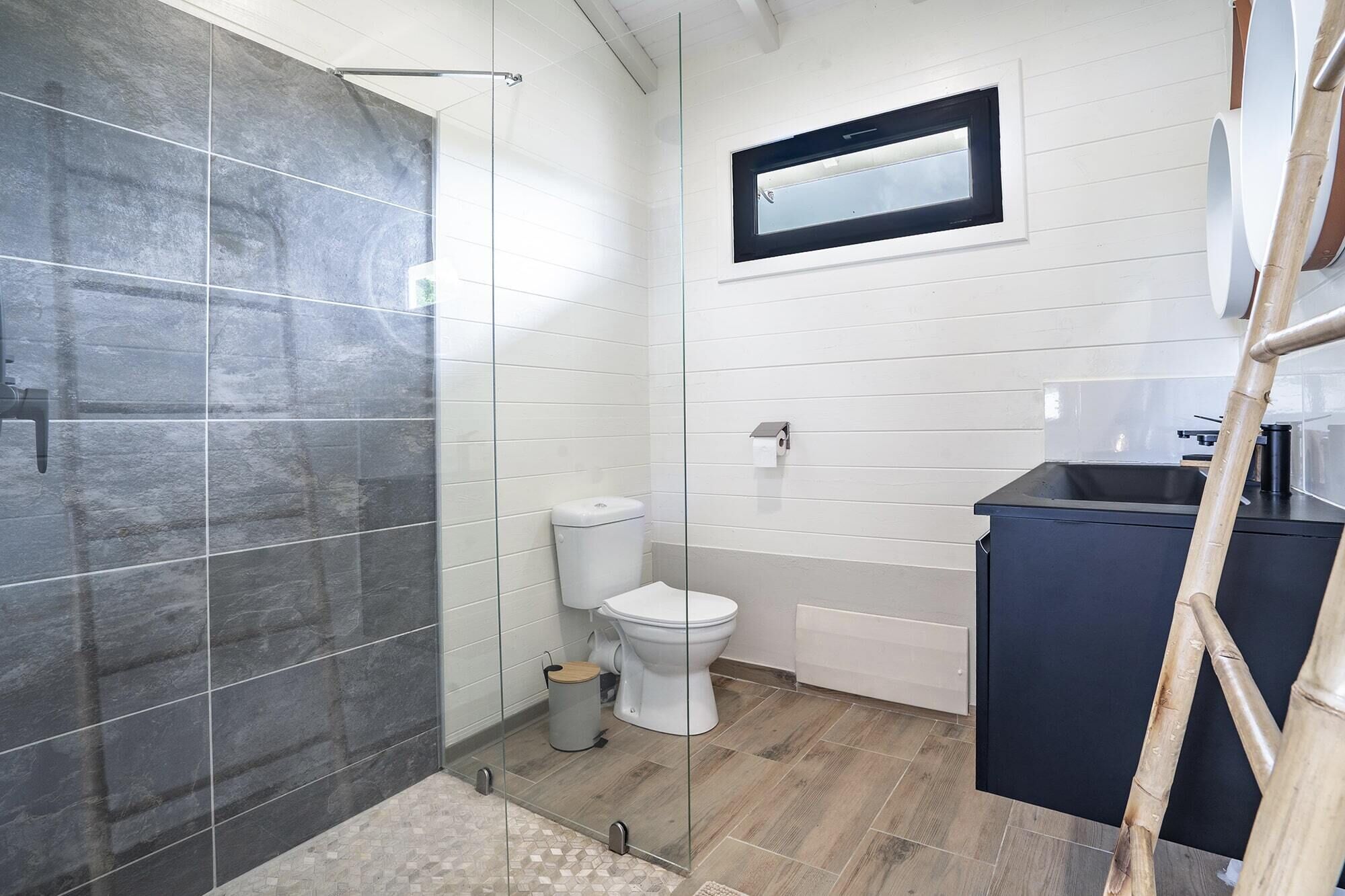 A bathroom with a shower, toilet, and sink.