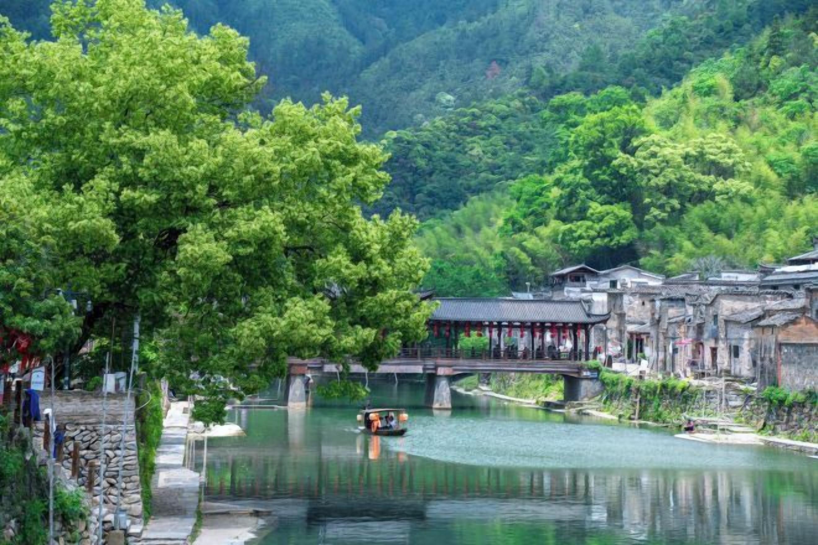 Une ville chinoise traditionnelle construite sur l’eau, avec une rivière, des ponts en bois et des bâtiments de style traditionnel.