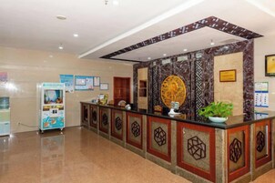 Un área de recepción con mostrador, máquina expendedora y una pared decorativa.