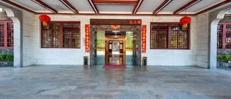 A spacious entrance with a tiled floor, wooden beams on the ceiling, and traditional red lanterns.
