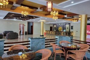 A hotel lobby with a reception desk, seating area, and a staircase leading to upper floors. - Yaoli Holiday Hotel (Fuliang)