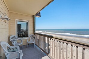 A wooden deck with a railing overlooking a beach. - Golden Strand Unit J2: Oceanfront | Shared Pool (Kill Devil Hills)