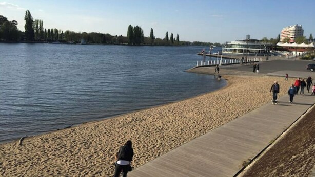 A sandy beach with a concrete walkway alongside a body of water. - F1 overlooking Lac d'Allier and park, 5' from thermal baths (Vichy)