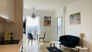 A modern apartment with a dining area, a living room, and a kitchen. There are two chairs, a round table, and a sofa. - City Apartment in Copenhagen with 1 bedrooms sleeps 2 (Copenhagen)