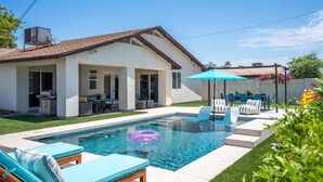 Une maison moderne dotée d’une piscine, de mobilier d’extérieur et d’un espace patio.