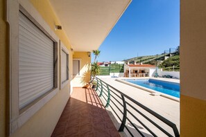 Enjoy a refreshing view of the pool from this balcony.