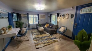 Ein Wohnzimmer mit einer Couch, zwei Sesseln, einem Couchtisch und einem Teppich.