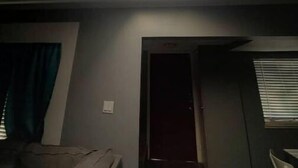 Ein Zimmer mit einem Oberlicht, einem Bett, einem Sessel und einer Tür.