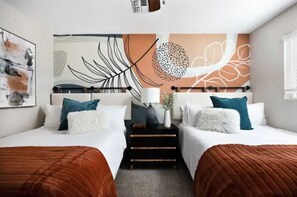 Habitación de hotel con dos camas, una mesita de noche, una obra de arte en la pared y una ventana.