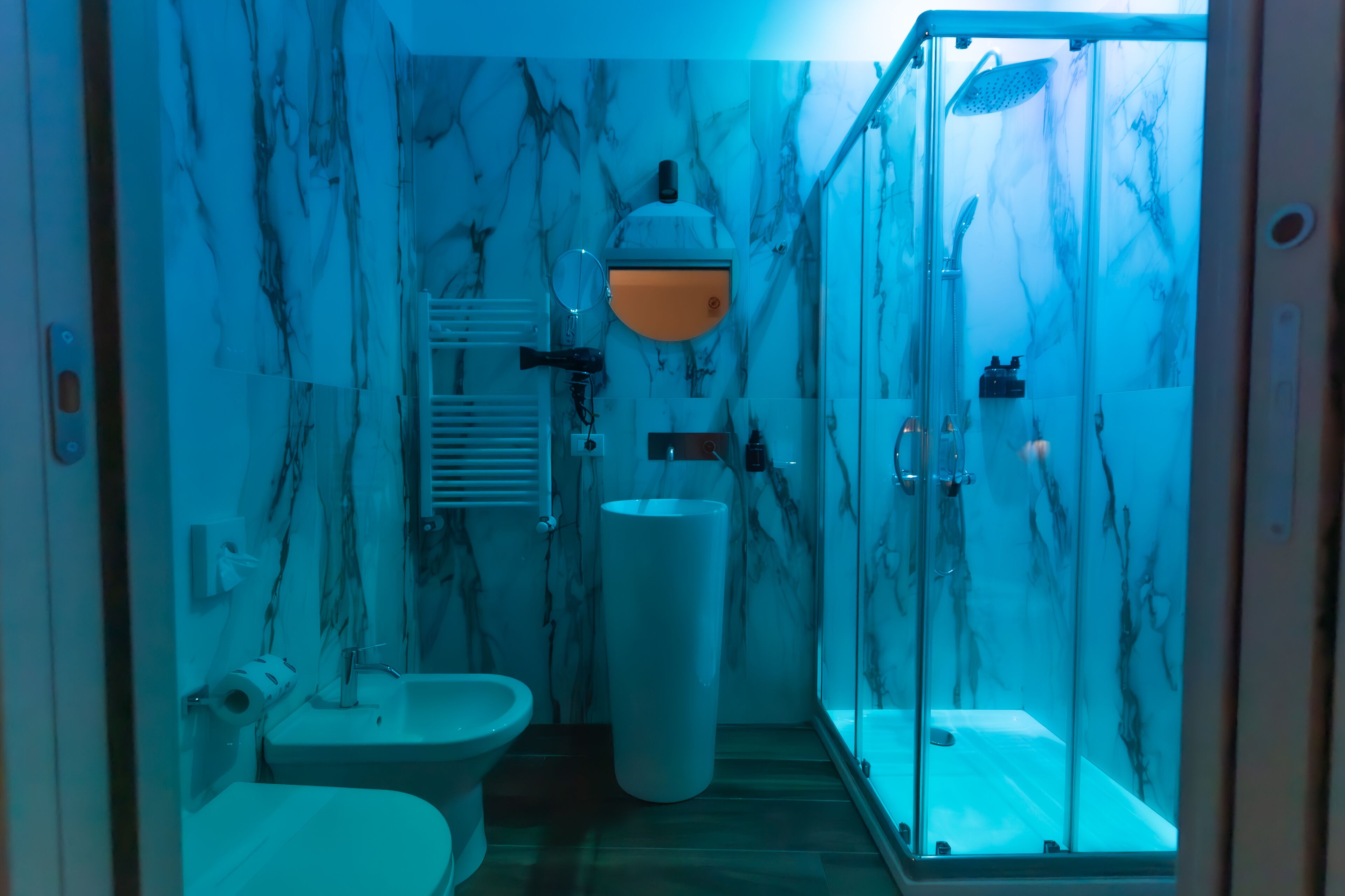 A bathroom with a toilet, sink, and glass-enclosed shower area.