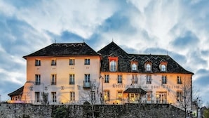 A hotel with a stone facade, multiple windows, and a sign indicating it is a restaurant.