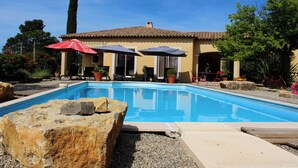 A swimming pool with a tiled deck, surrounded by potted plants and outdoor furniture. - Rental Residence Peylon with swimming pool terrace garden patio in a quiet area (Flayosc)