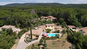 A residential area with multiple houses, a swimming pool, and a forested backdrop. - Rental Residence Peylon with swimming pool terrace garden patio in a quiet area (Flayosc)