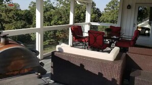 A covered outdoor seating area with a grill, wicker furniture, and a view of trees. - 0ver 7,000 Sq ft of tranquil relaxation  (Shawnee)
