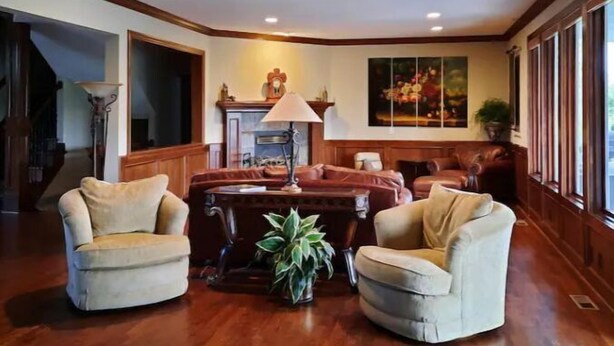 A spacious living room with a fireplace, leather armchairs, and a large window. - 0ver 7,000 Sq ft of tranquil relaxation  (Shawnee)