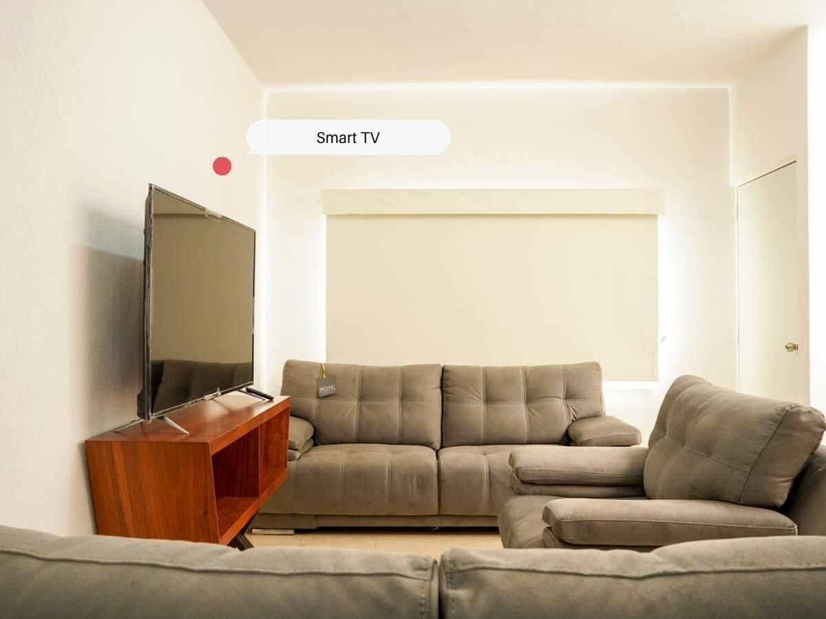 A living room with a sofa, a TV, and a wooden side table.