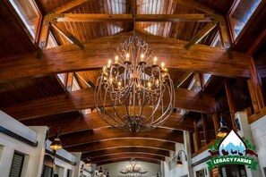 Experience the grandeur of Legacy Farms' traditional interior, featuring a stunning vaulted ceiling and elegant chandelier.