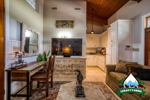 Cozy living space with a dining table, sofa, and stone fireplace.