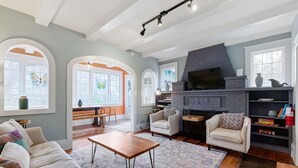 A spacious living room with a fireplace, comfortable seating, and large windows. - 8 Park l Dog Friendly l Outdoor Oasis l Mins to Beach (St. Augustine)