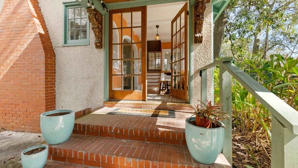 A building entrance with a wooden staircase, a door, and two potted plants. - 8 Park l Dog Friendly l Outdoor Oasis l Mins to Beach (St. Augustine)
