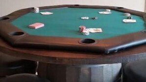 Ein Billardtisch mit Chips und ein Pokertisch mit vier Hockern.