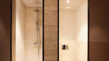 A modern bathroom with a shower, toilet, and a mirror.