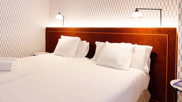 Una habitación de hotel con una cama bien hecha, cabecera con detalles de madera y pared con estampado.