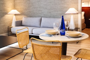 A dining area with a round table, two chairs, a sofa, and two lamps. - THE Apartment by Assethoteles (Torrejón de Ardoz)