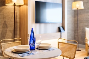 A dining table with two chairs, a bottle, and a glass. - THE Apartment by Assethoteles (Torrejón de Ardoz)