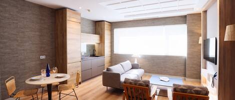 A modern living space with a kitchen, dining area, and seating.
