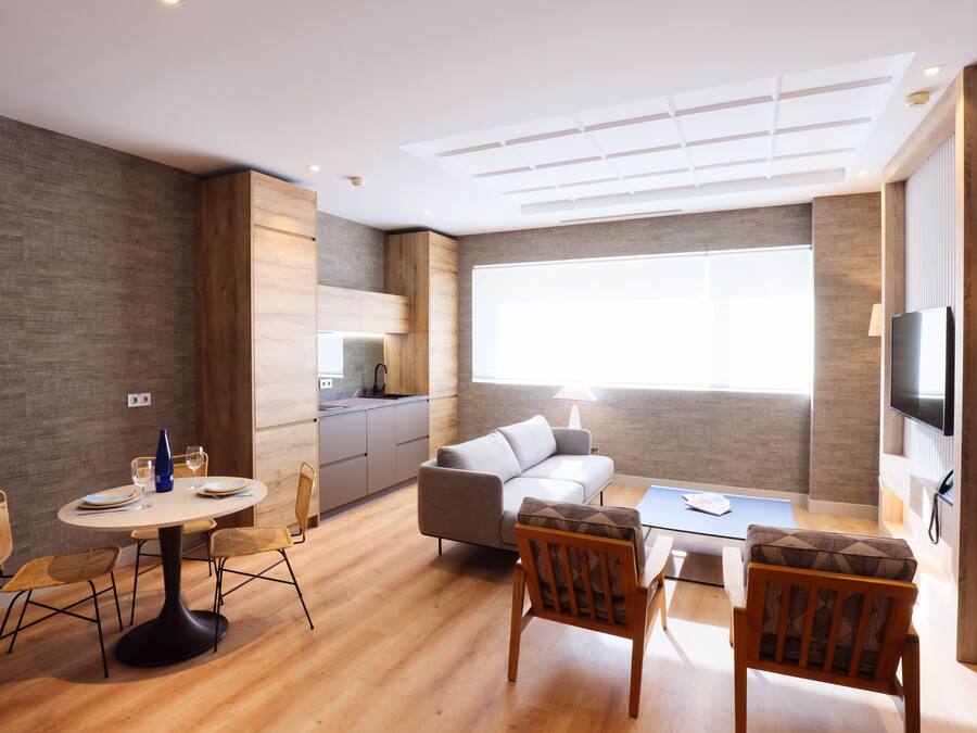 Un espacio de estar moderno con cocina, comedor y asientos.