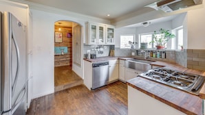 A modern kitchen with stainless steel appliances, wooden flooring, and a view of the backyard. - Pet-Friendly Austin Home w/ Private Yard + Deck! (Austin)
