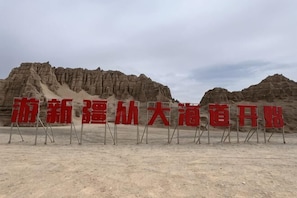 A desert landscape with rocky formations and a clear sky. - Jiulong Holiday Hotel (Hami)