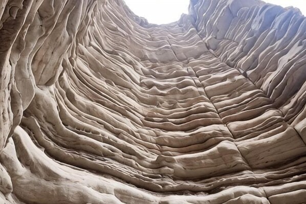 A rock formation with layered textures and a narrow passageway. - Jiulong Holiday Hotel (Hami)