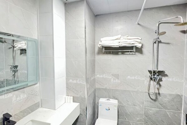 A modern bathroom with a glass shower enclosure, a white sink, and a towel rack. - Jiulong Holiday Hotel (Hami)